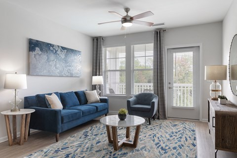 a living room with a blue couch and a ceiling fan